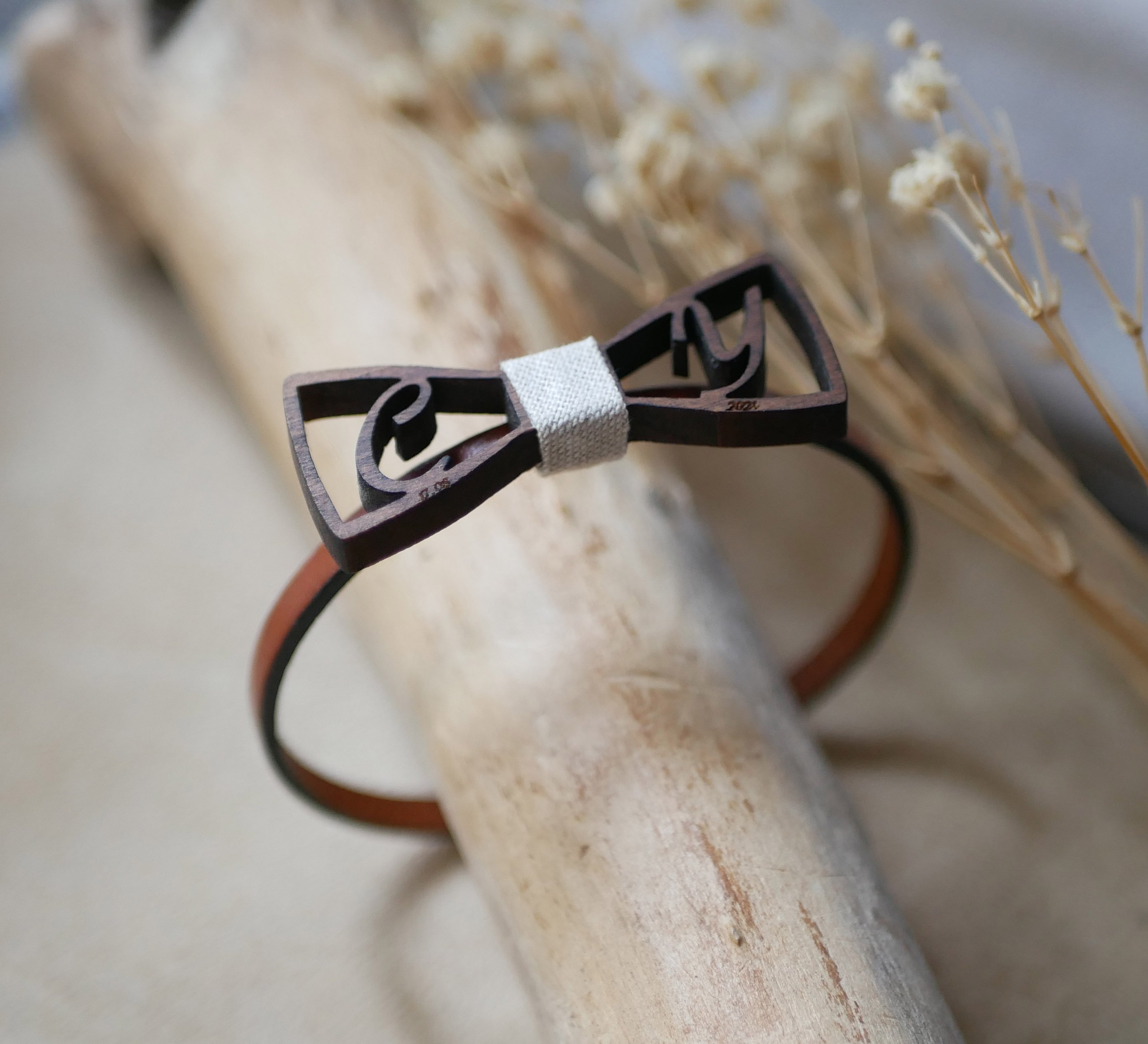 Pulseira de couro com laço de madeira em miniatura e iniciais a céu aberto