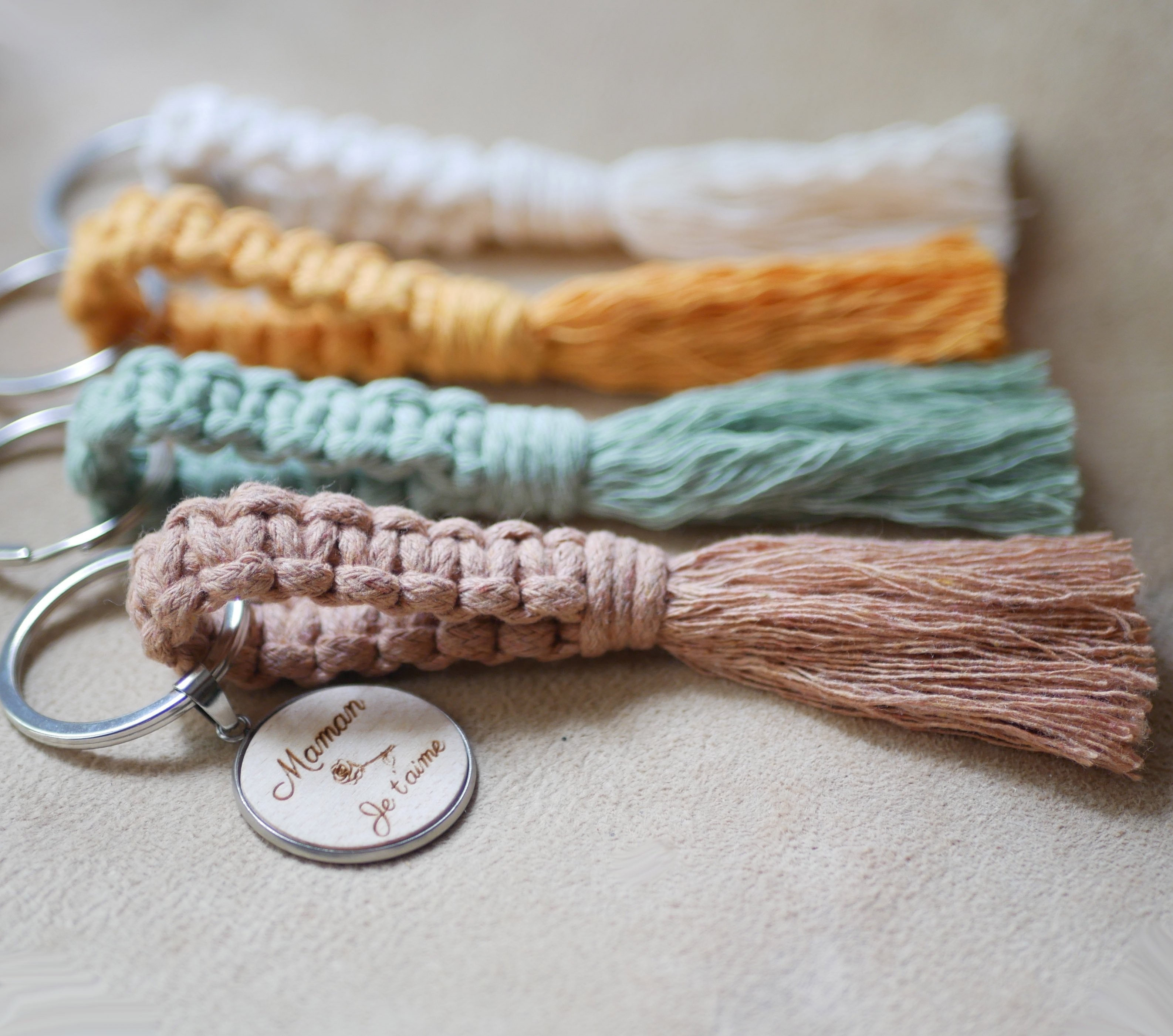 Porta-chaves com cabochão de madeira personalizado e decoração em macramé numa seleção de cores 